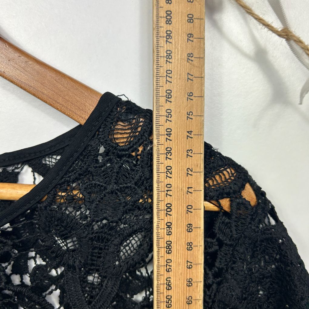 Black lace top detail view with wooden hanger and measuring tape