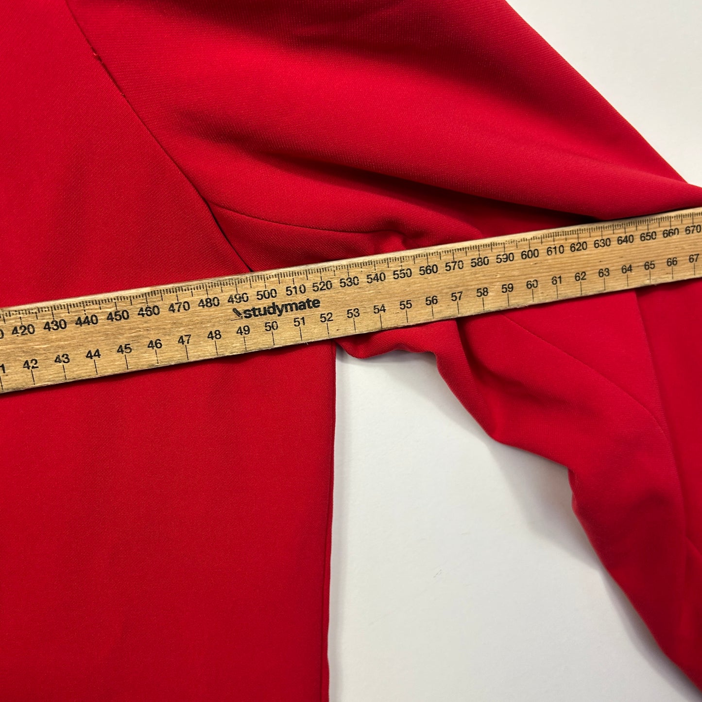 Red fabric detail view with measuring tape