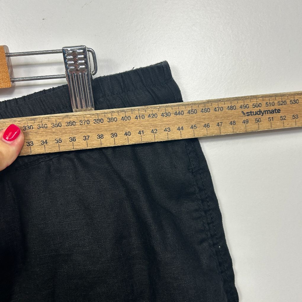 Black shorts being measured with tape measure detail view
