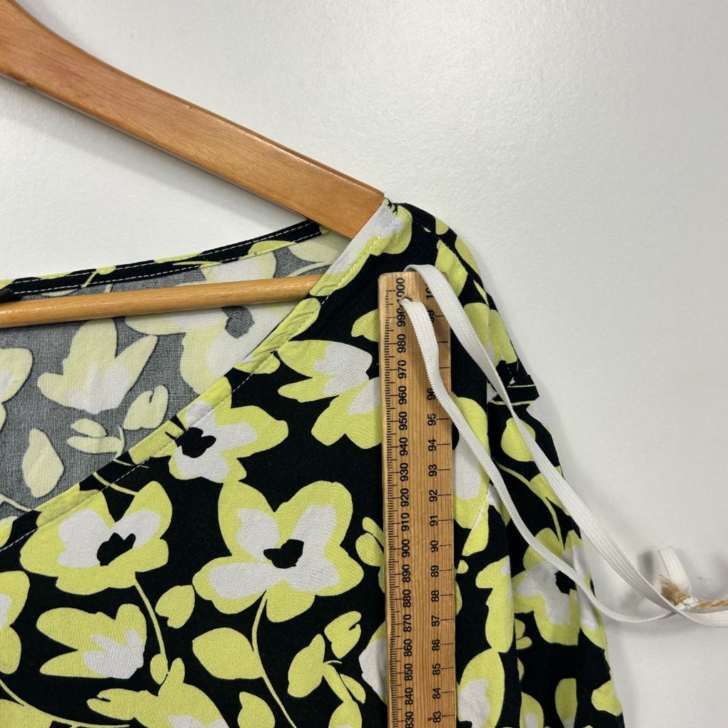 Yellow and black floral print top detail view on hanger
