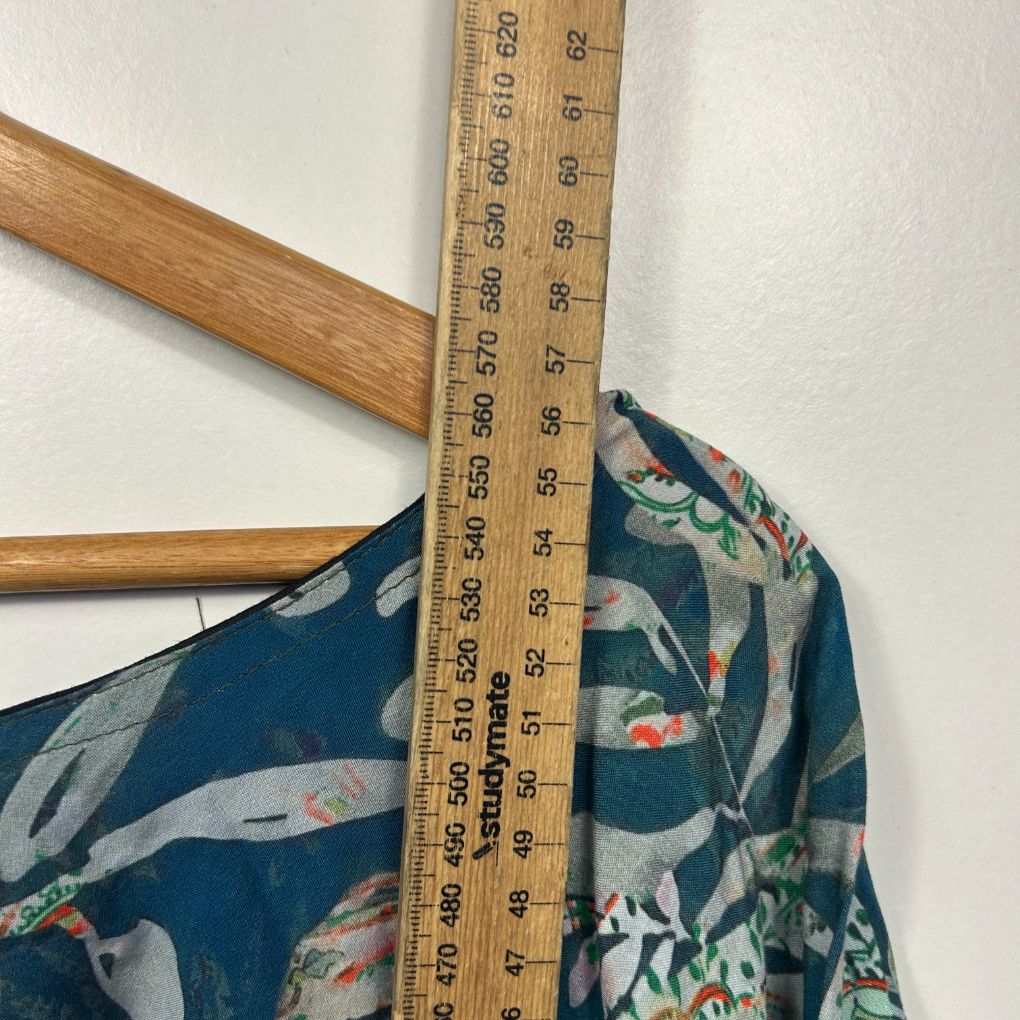 Teal floral blouse front view with measuring tape