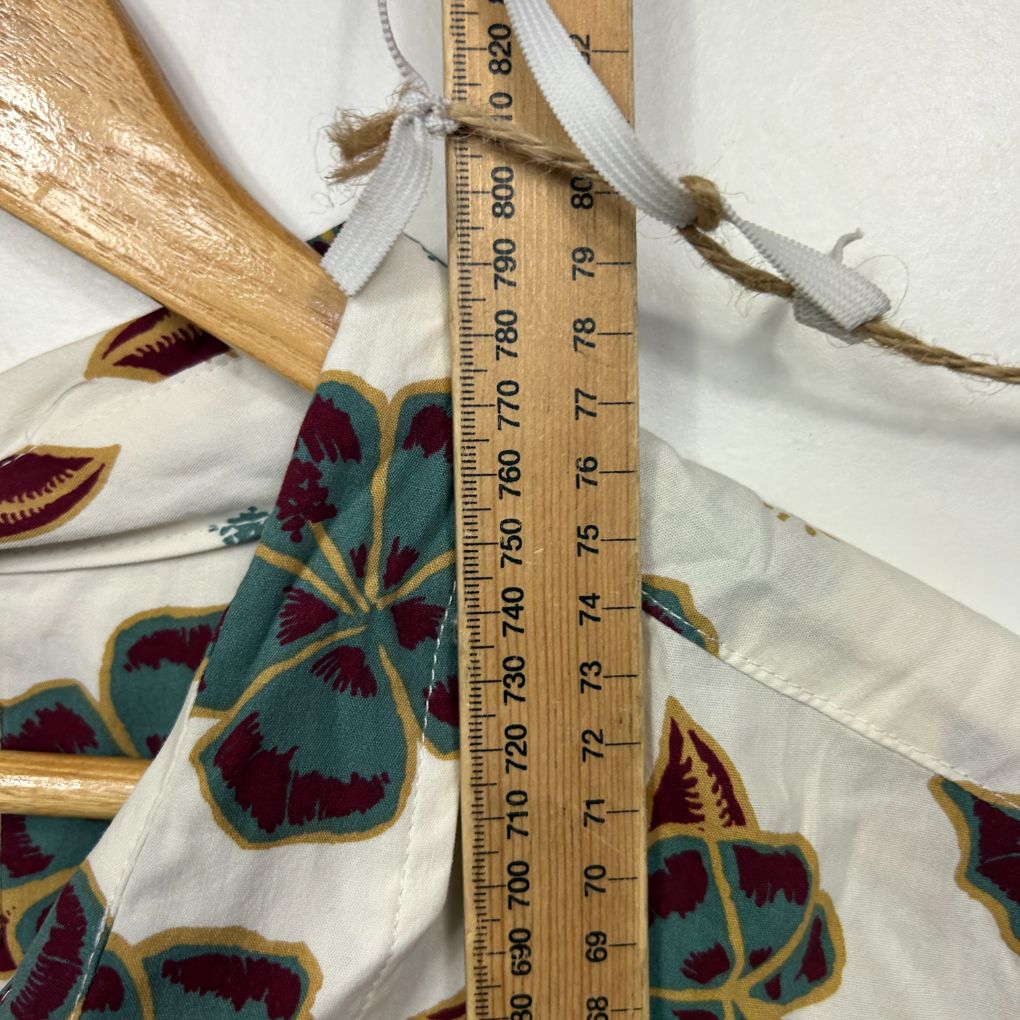 Cream fabric with burgundy and teal floral pattern detail view