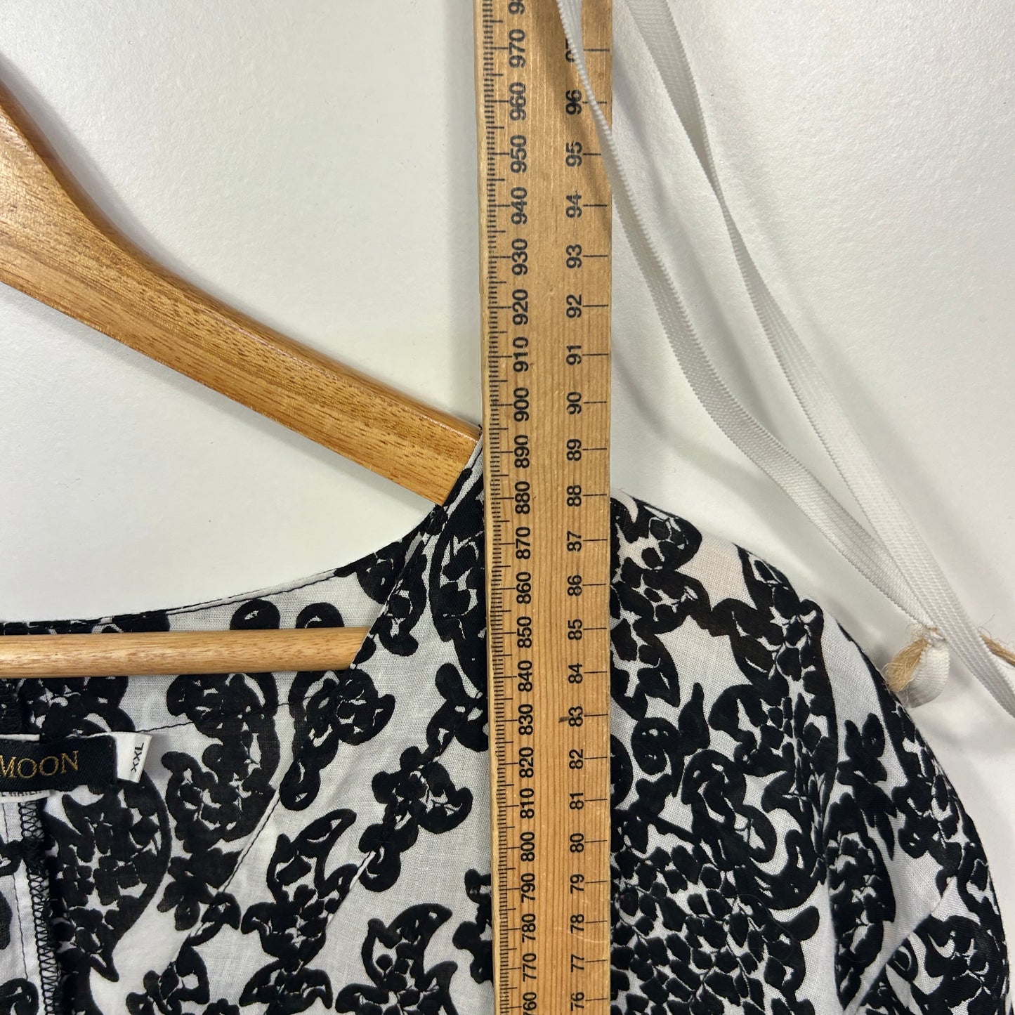 Black and white floral patterned top detail view with measuring tape