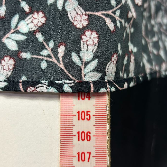 Dark green floral dress detail view with measurement ruler