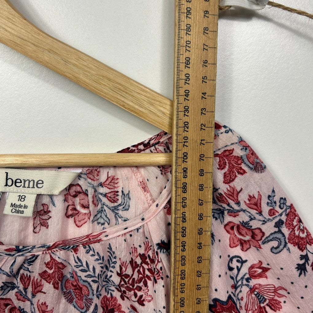 Pink floral dress detail view with measuring tape