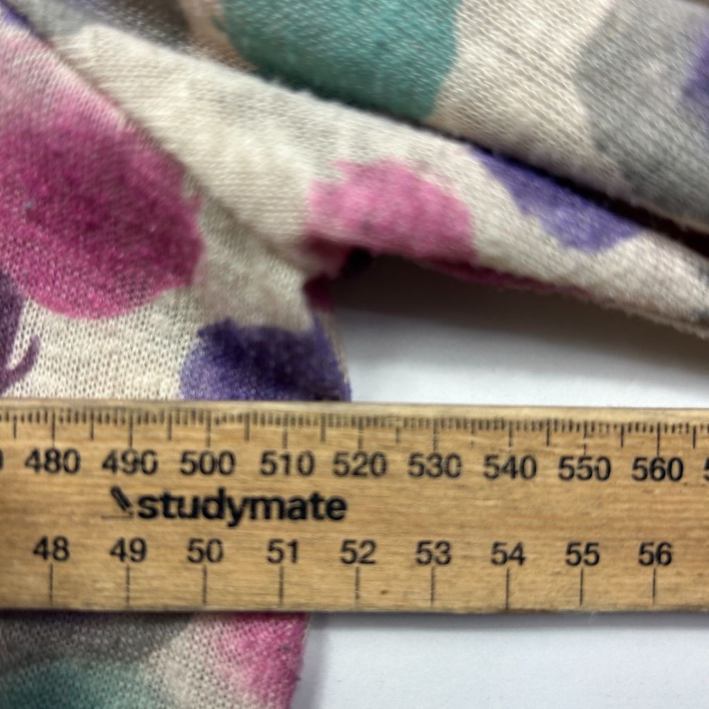 Multicoloured patterned knit fabric detail view with ruler