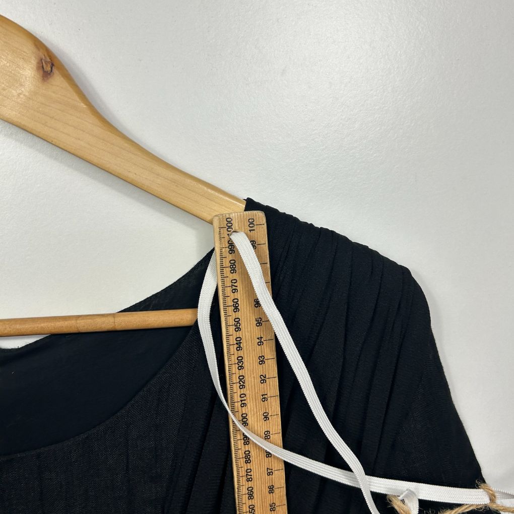 Black top on wooden hanger detail view with measuring tape