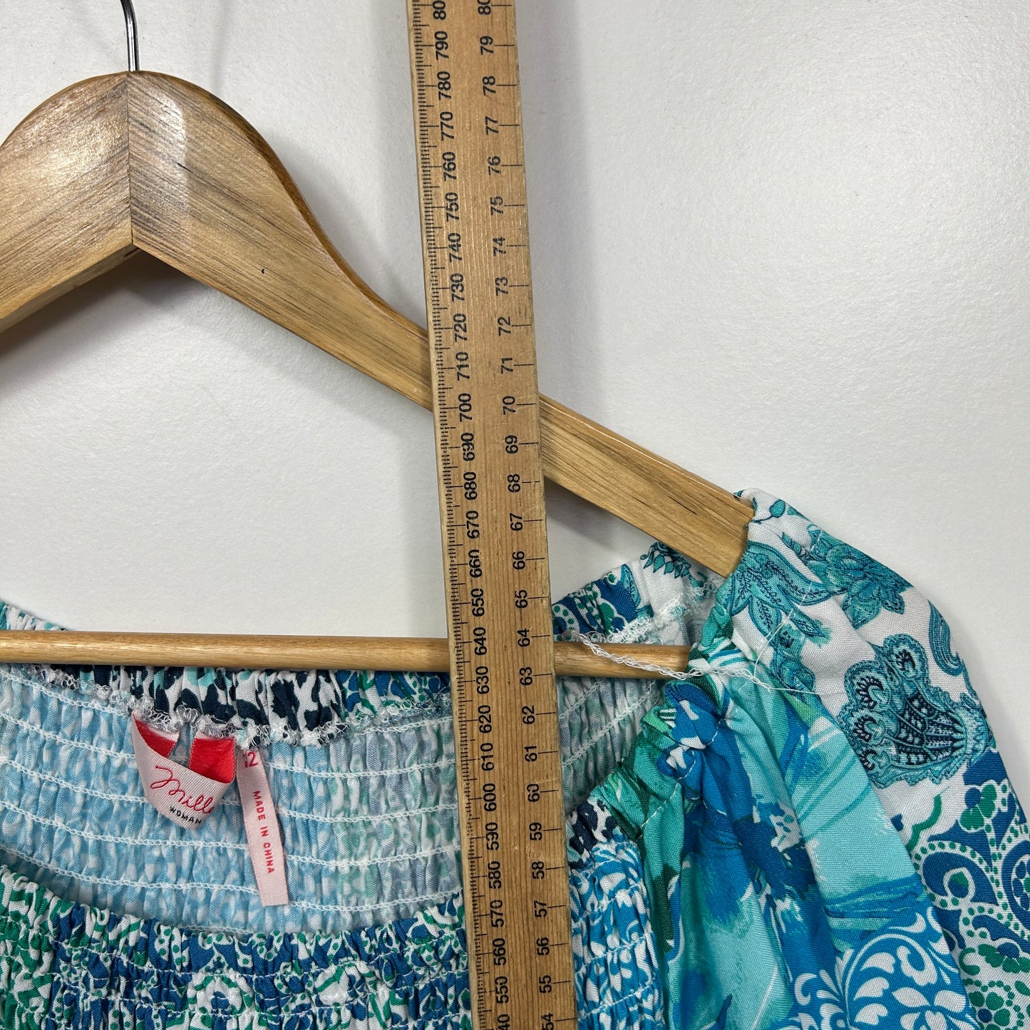 Wooden coat hanger with patterned garments detail view