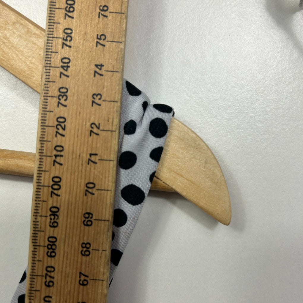 White fabric with black polka dots detail view on ruler