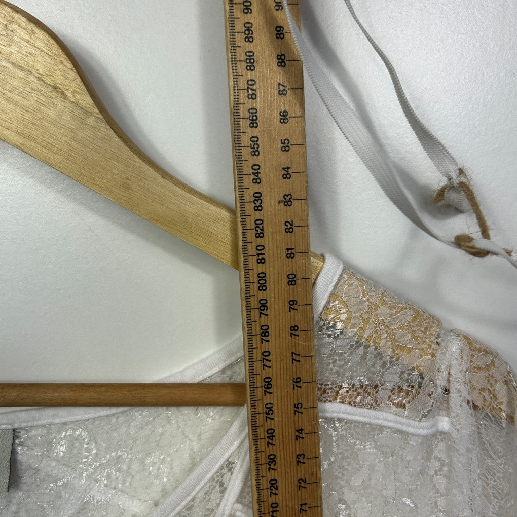 Beige lace garment detail view with measuring tape