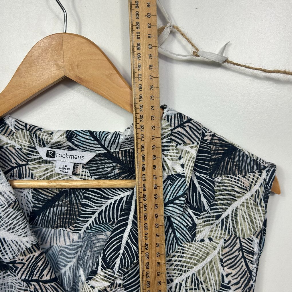 Black and white leaf print sleeveless top flat lay with wooden hanger and measuring tape