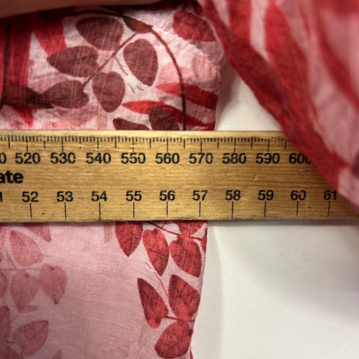 Red floral fabric with measurement ruler detail view