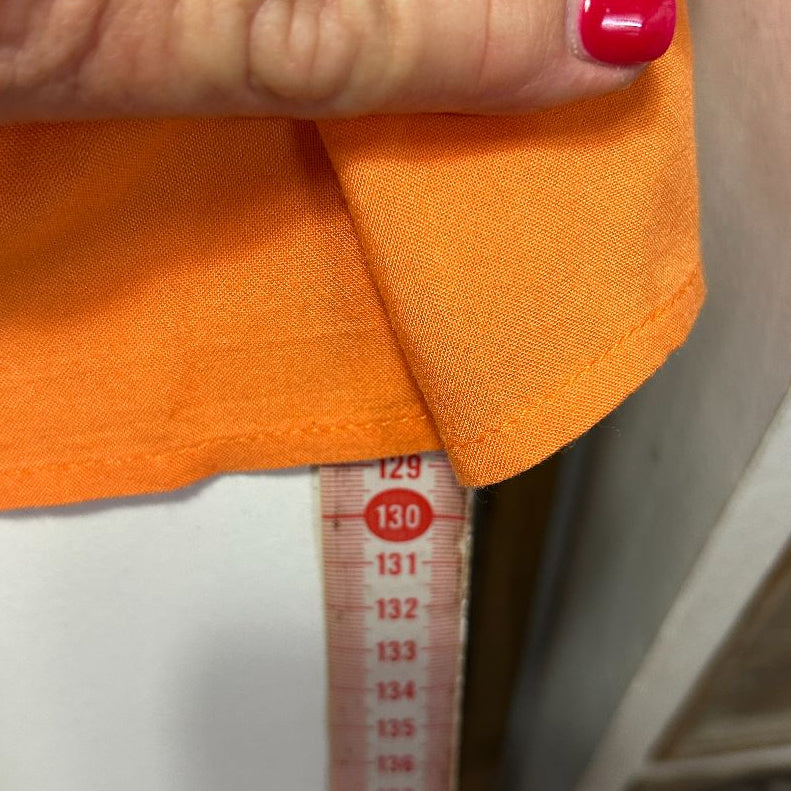 Orange sweater detail view with measuring tape