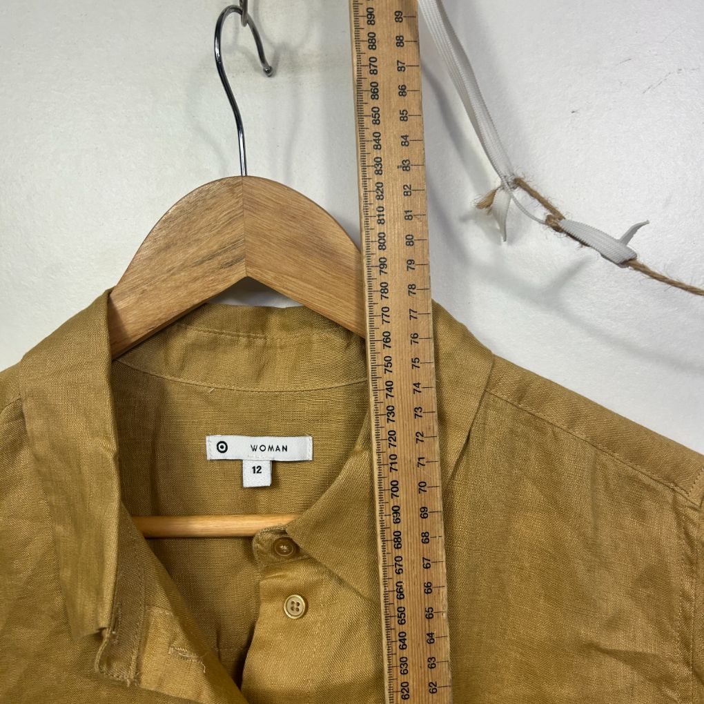 Mustard yellow button-up shirt front view on wooden hanger