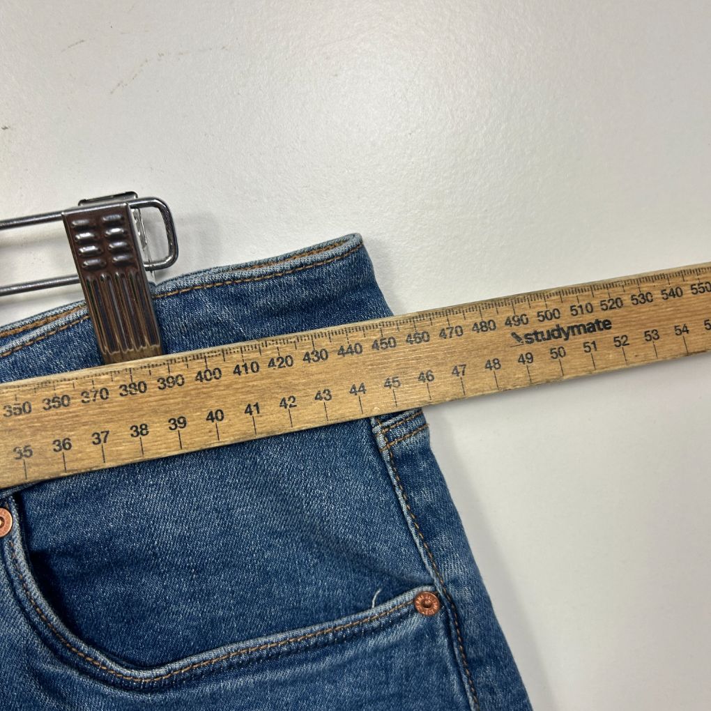 Blue jeans with measuring tape and belt detail view