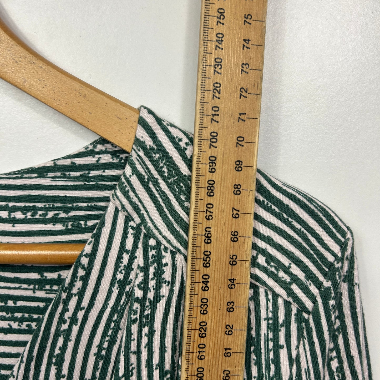 Green and white striped shirt detail view with measuring tape