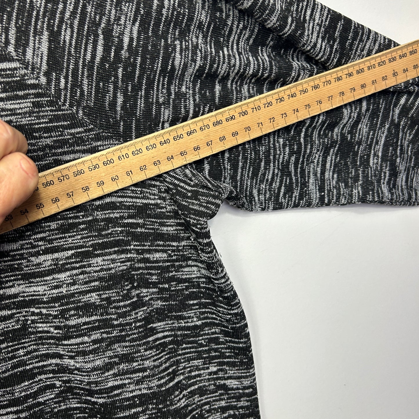 Black and white striped knit fabric detail view with measuring tape