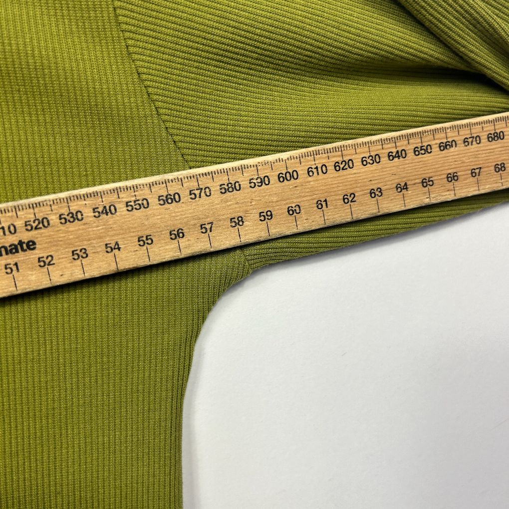 Green ribbed fabric with measuring tape detail view