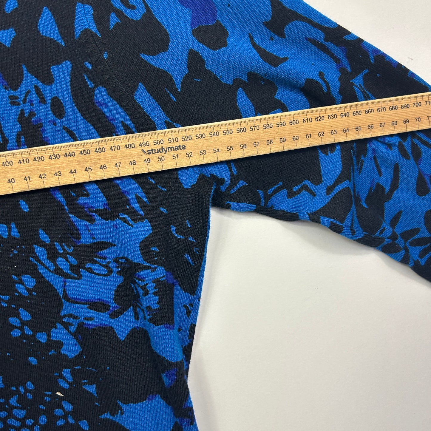 Blue and black camouflage fabric detail view with measuring tape