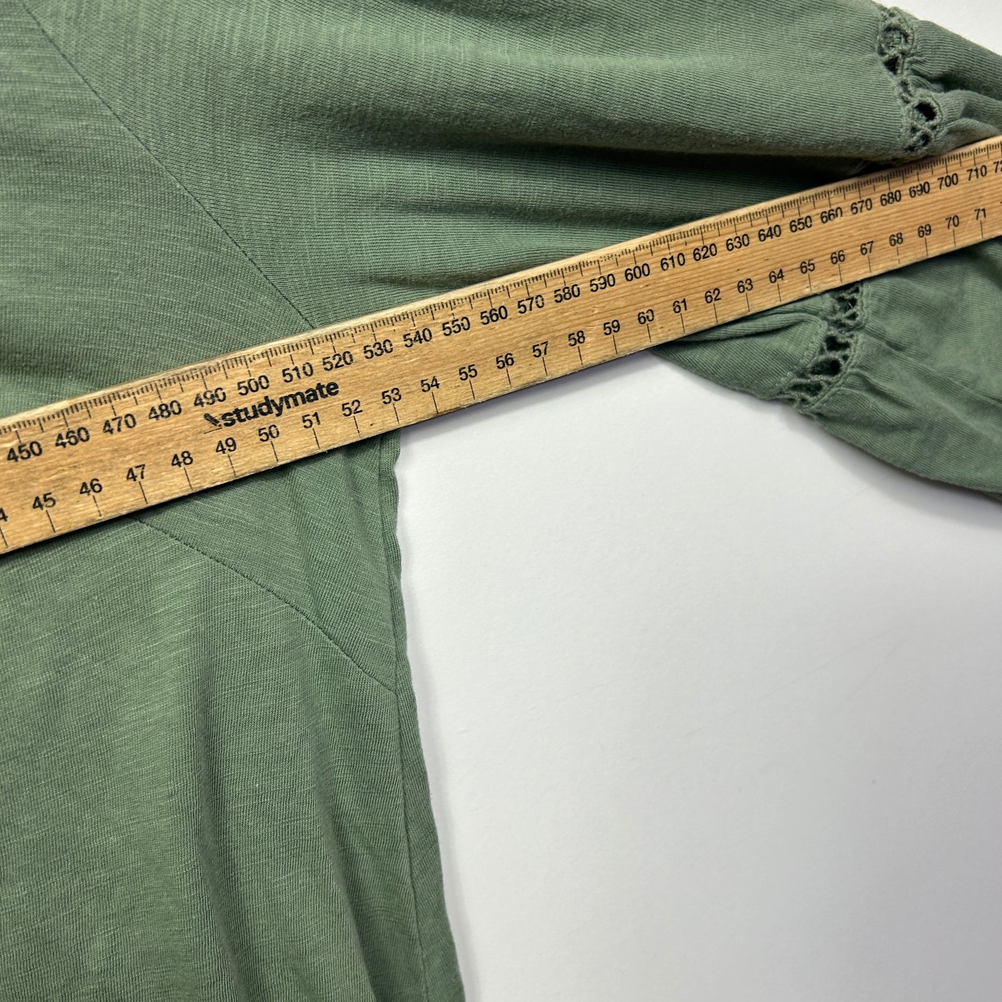 Sage green fabric with measuring tape detail view