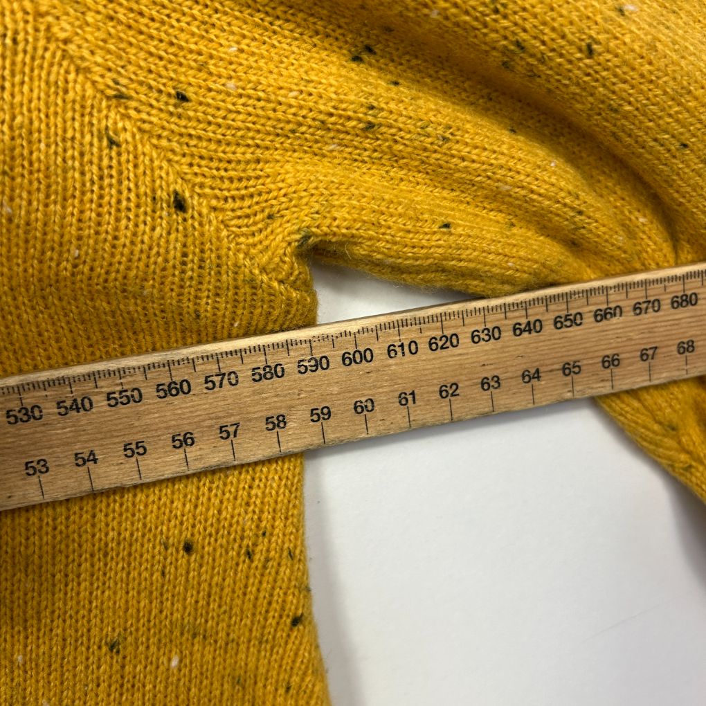 Golden yellow knit jumper detail view with measuring tape