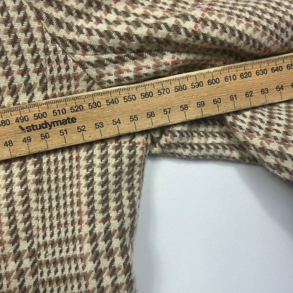 Beige knit fabric detail view with measuring tape