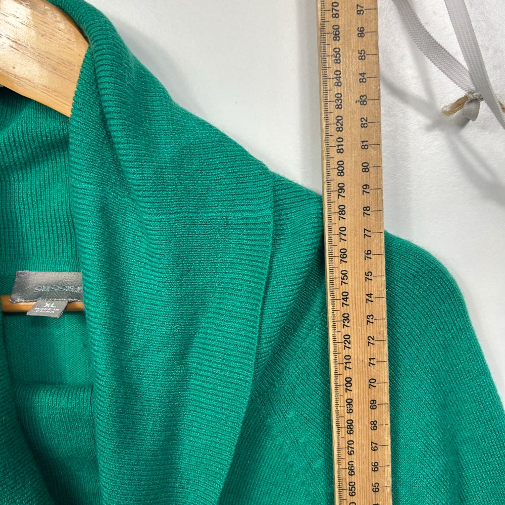 Green knit cardigan detail view with measuring tape