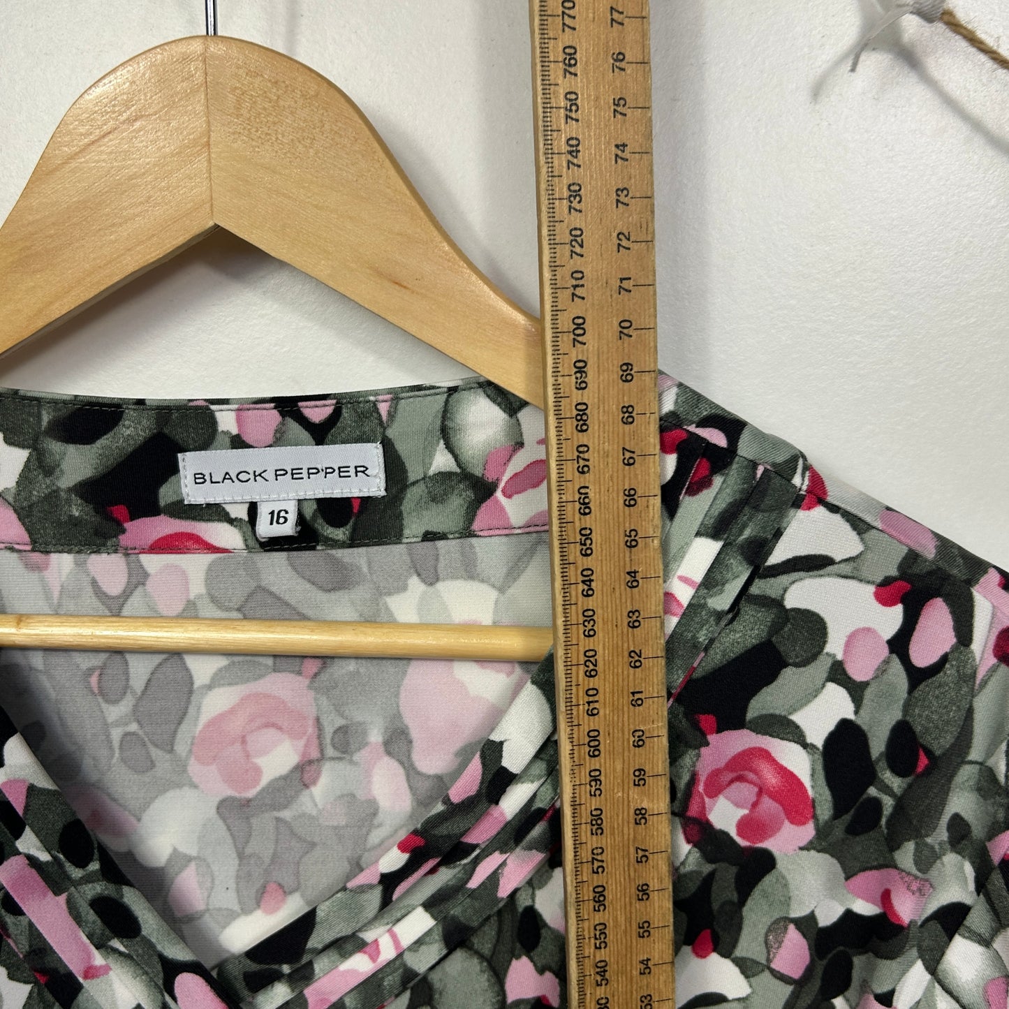 Black Pepper floral top detail view showing label and measurement