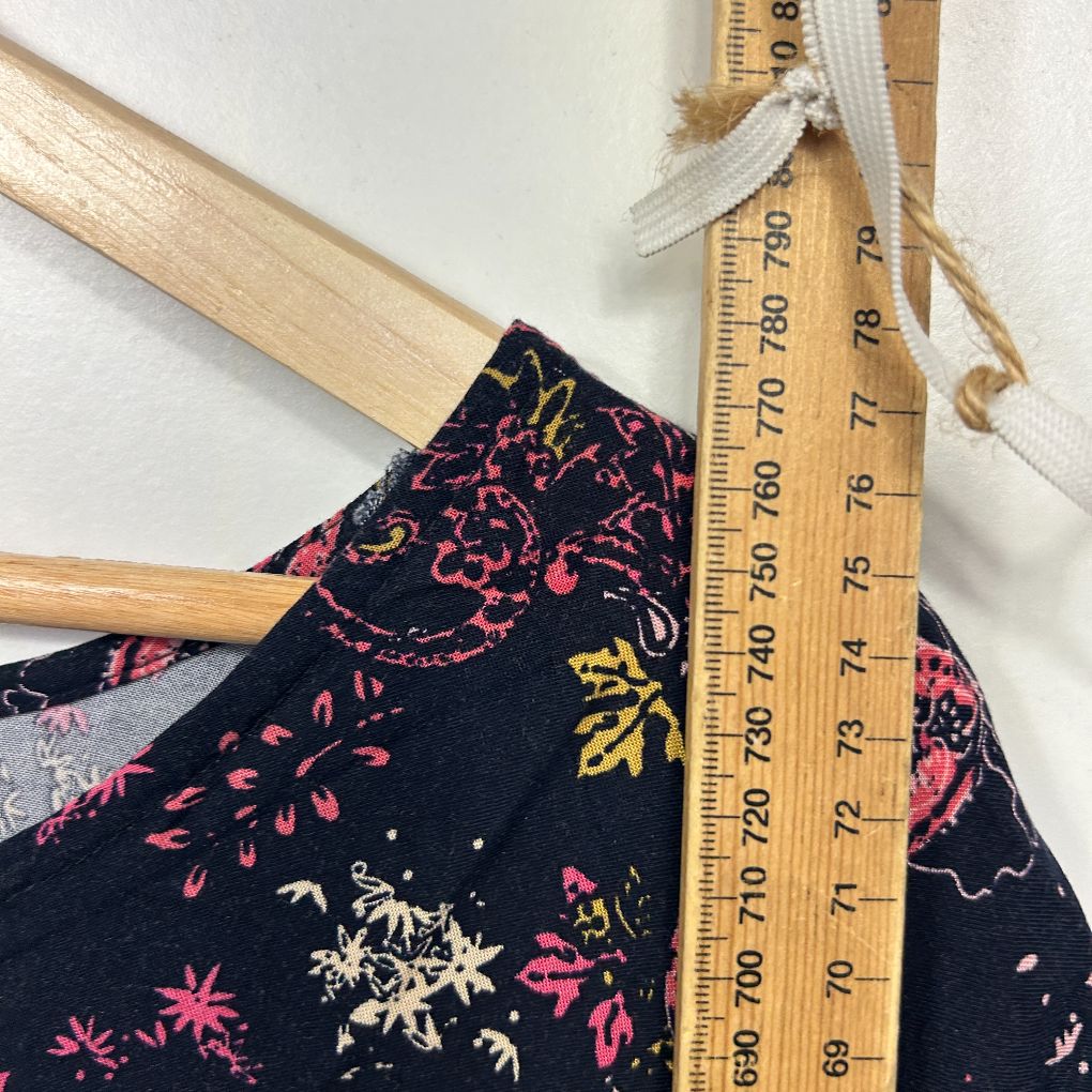 Black floral top detail view with measuring tape
