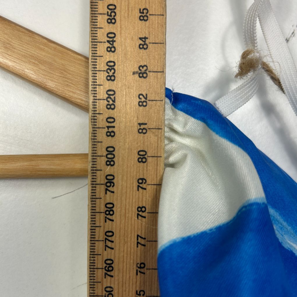 Blue garment being measured against ruler detail view