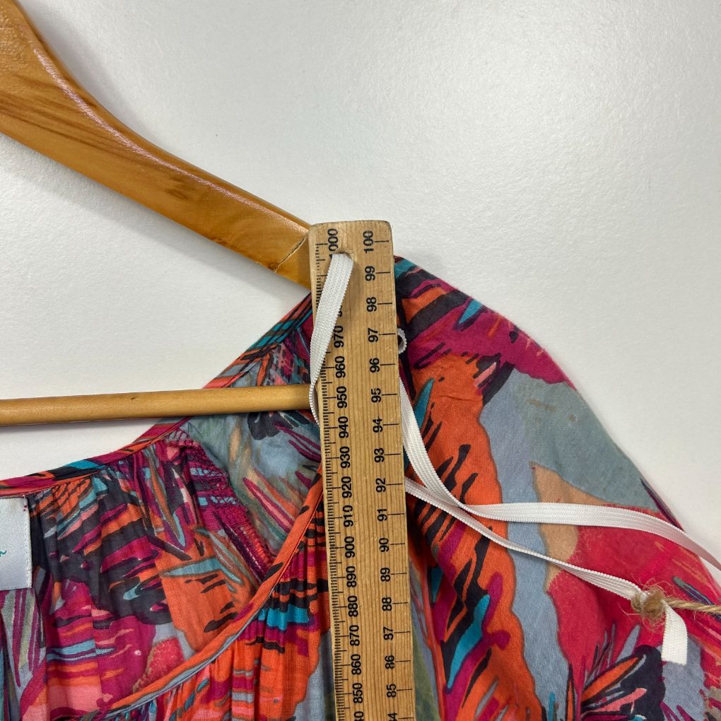 Colourful floral patterned garment detail view with measuring tape