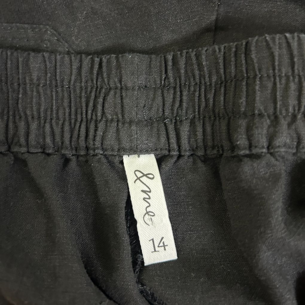 Black pants detail view showing elastic waistband and size label