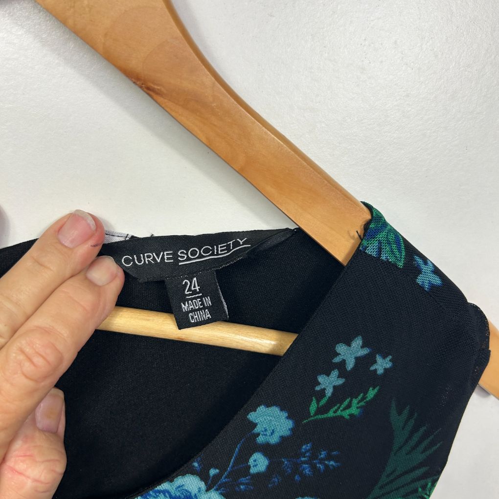 Black top with teal floral print detail view