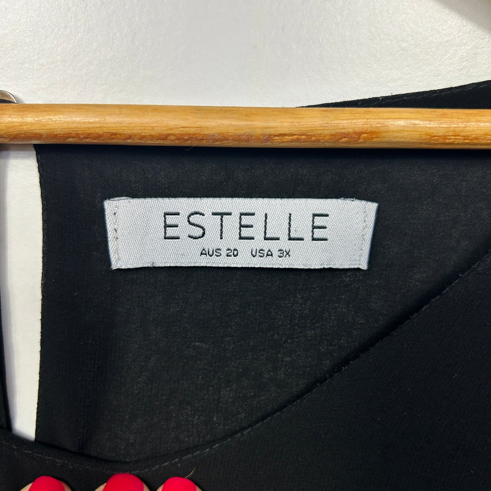 Black top label detail view showing Estelle brand tag