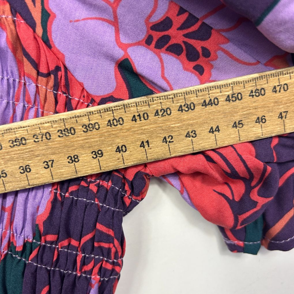 Purple and red floral patterned fabric with measuring tape detail view