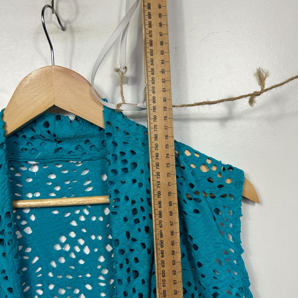 Teal crochet vest front view with wooden hanger