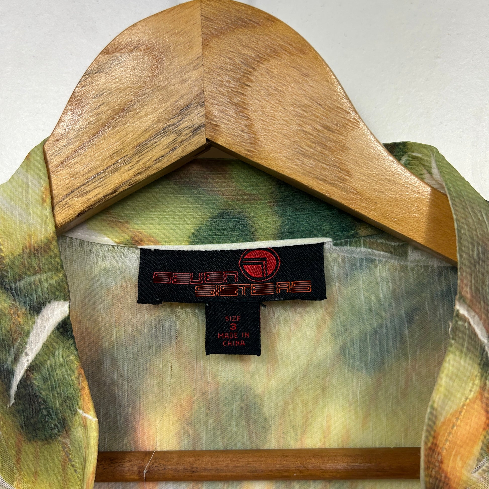 Green and yellow checked shirt front view on wooden hanger