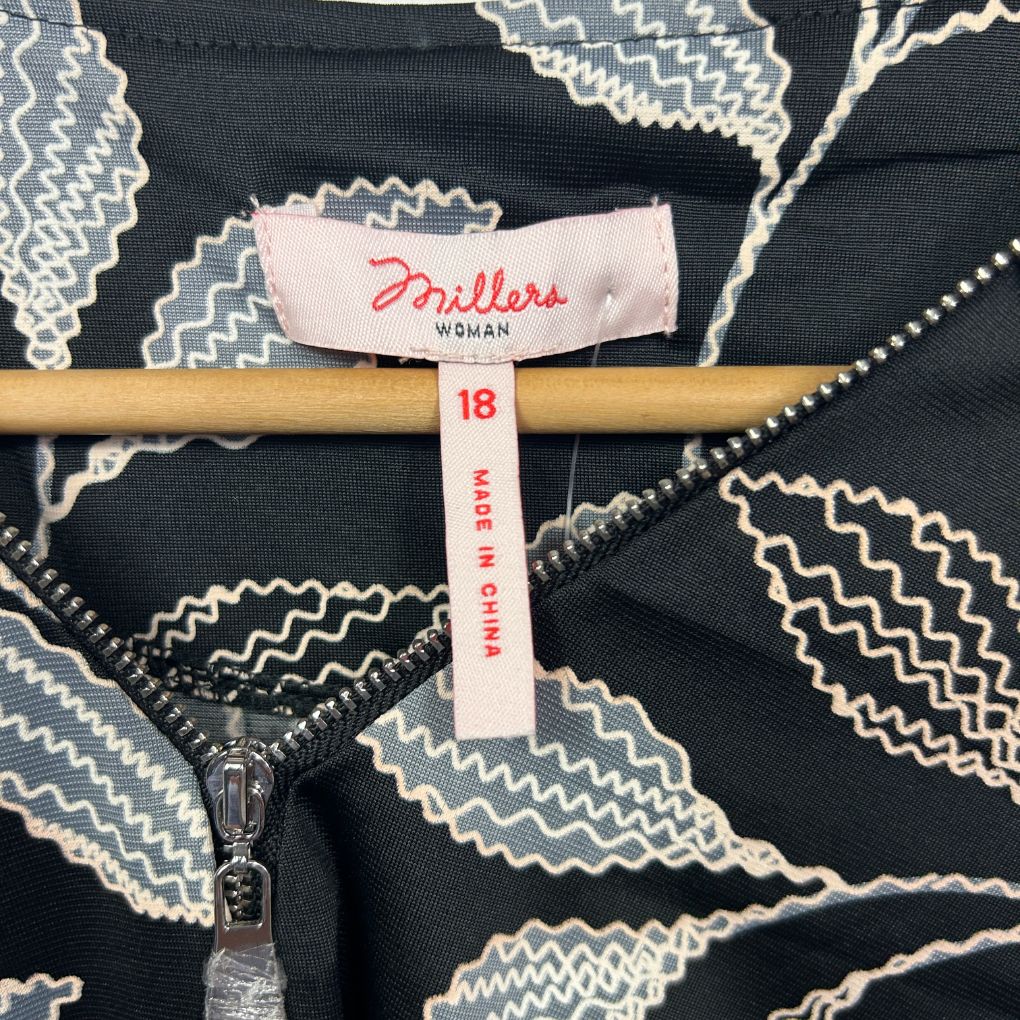 Black and cream geometric patterned jacket detail view showing label