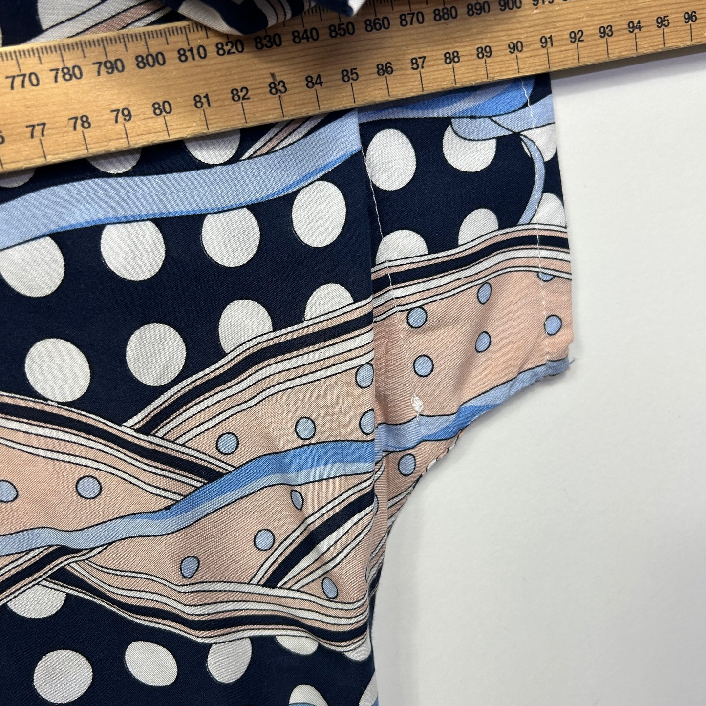 Navy polka dot and striped fabric detail view with measuring tape