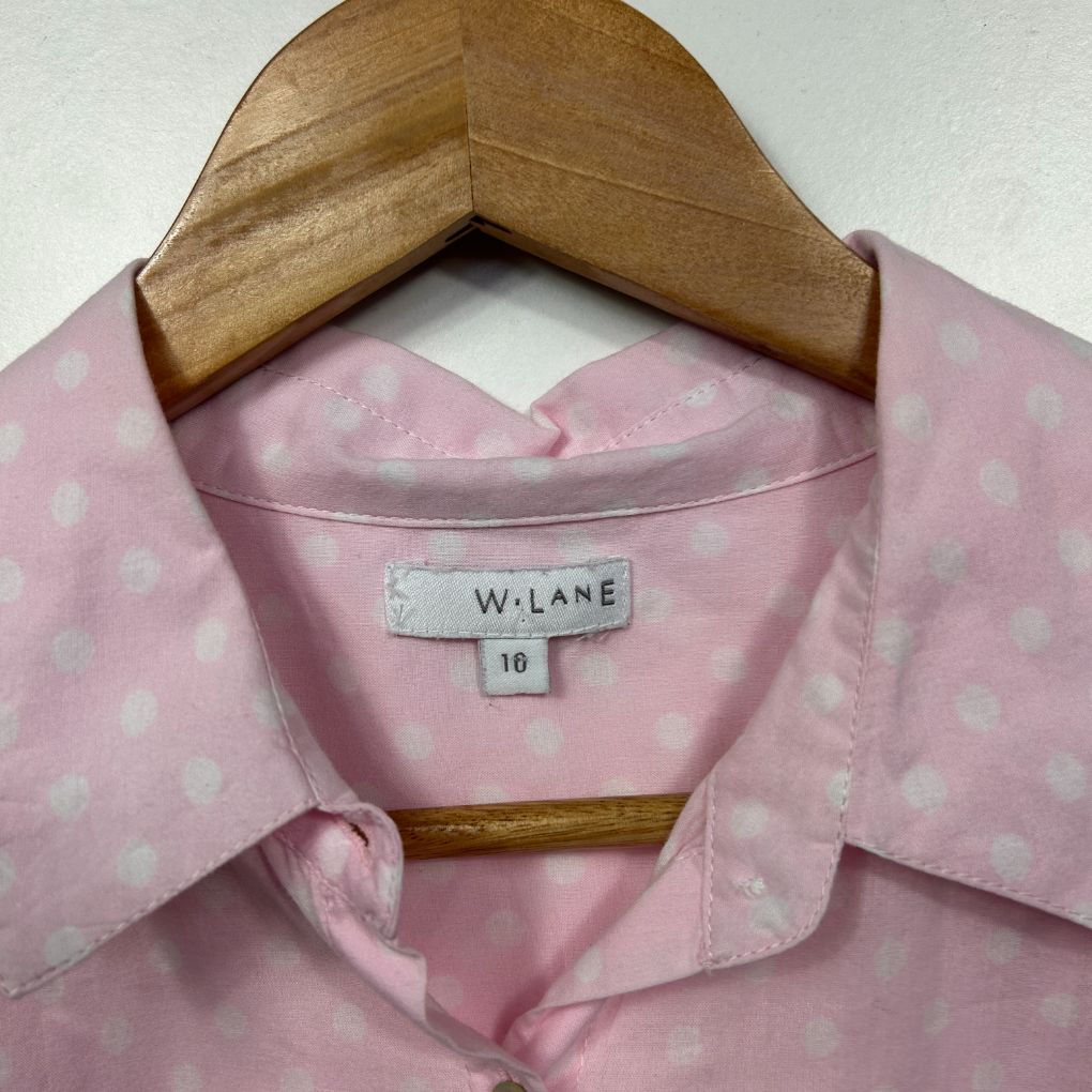 Pink polka dot shirt front view on wooden hanger