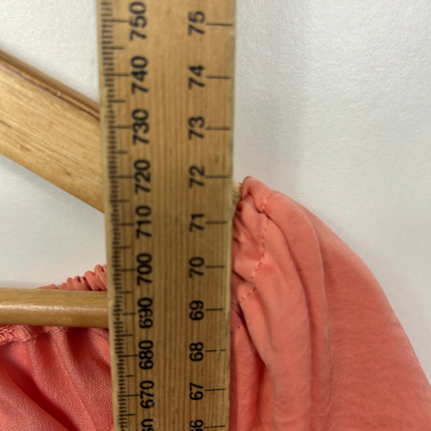 Pink fabric detail view with measuring ruler