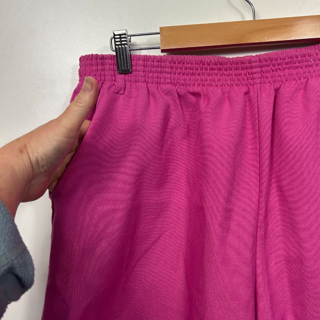 Magenta shorts detail view showing elastic waistband and fabric texture