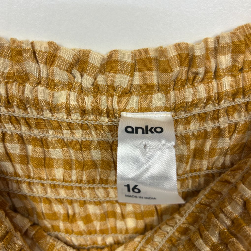 Gold and white checked pants label detail view