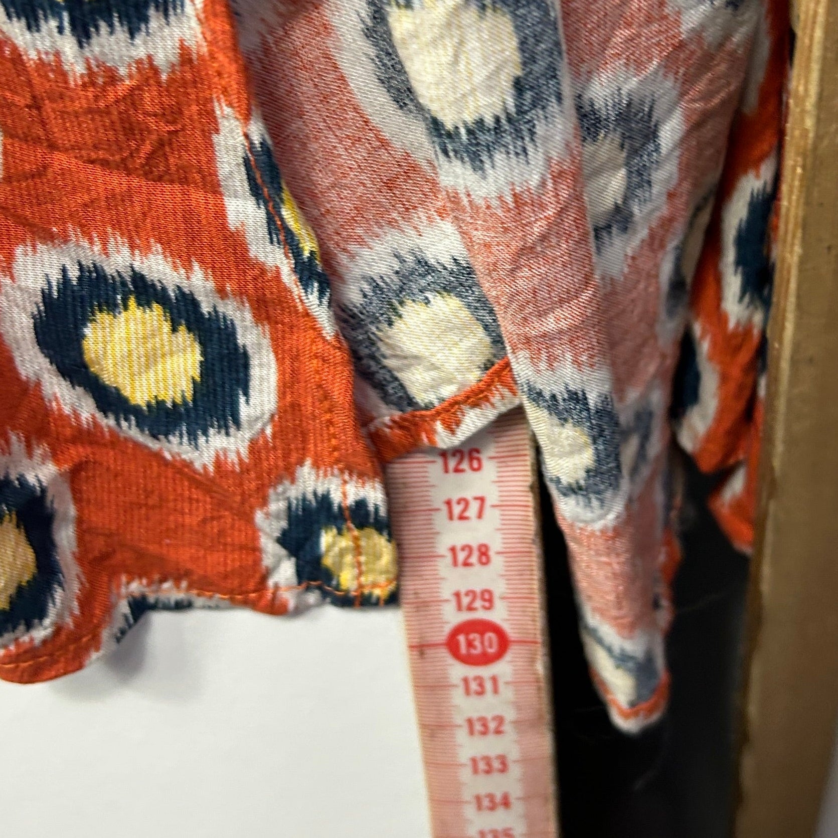 Orange cardigan with ikat pattern detail view