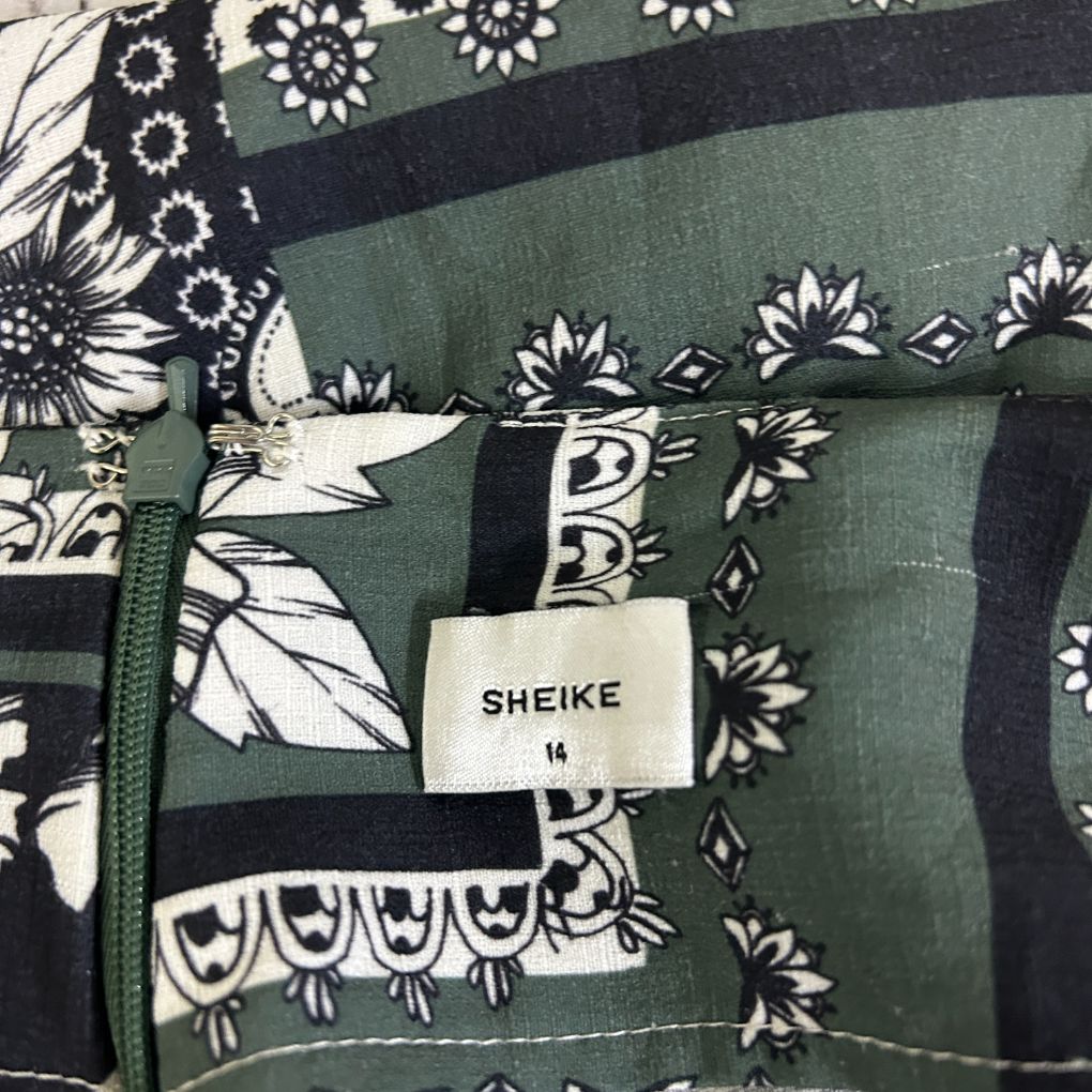 Green and black patterned fabric detail view with floral and geometric design