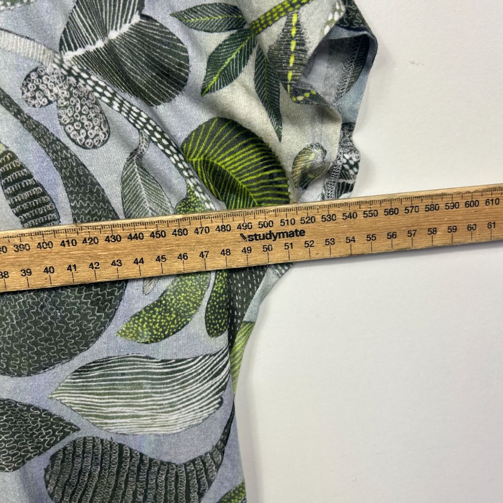 Grey and green leaf print fabric with measuring tape detail view
