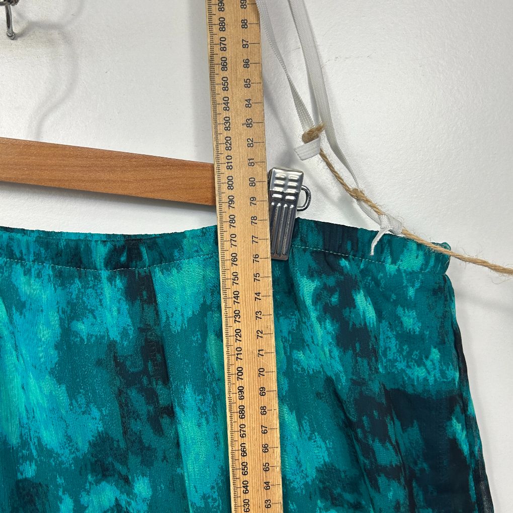 Teal velvet fabric detail view with measuring tape