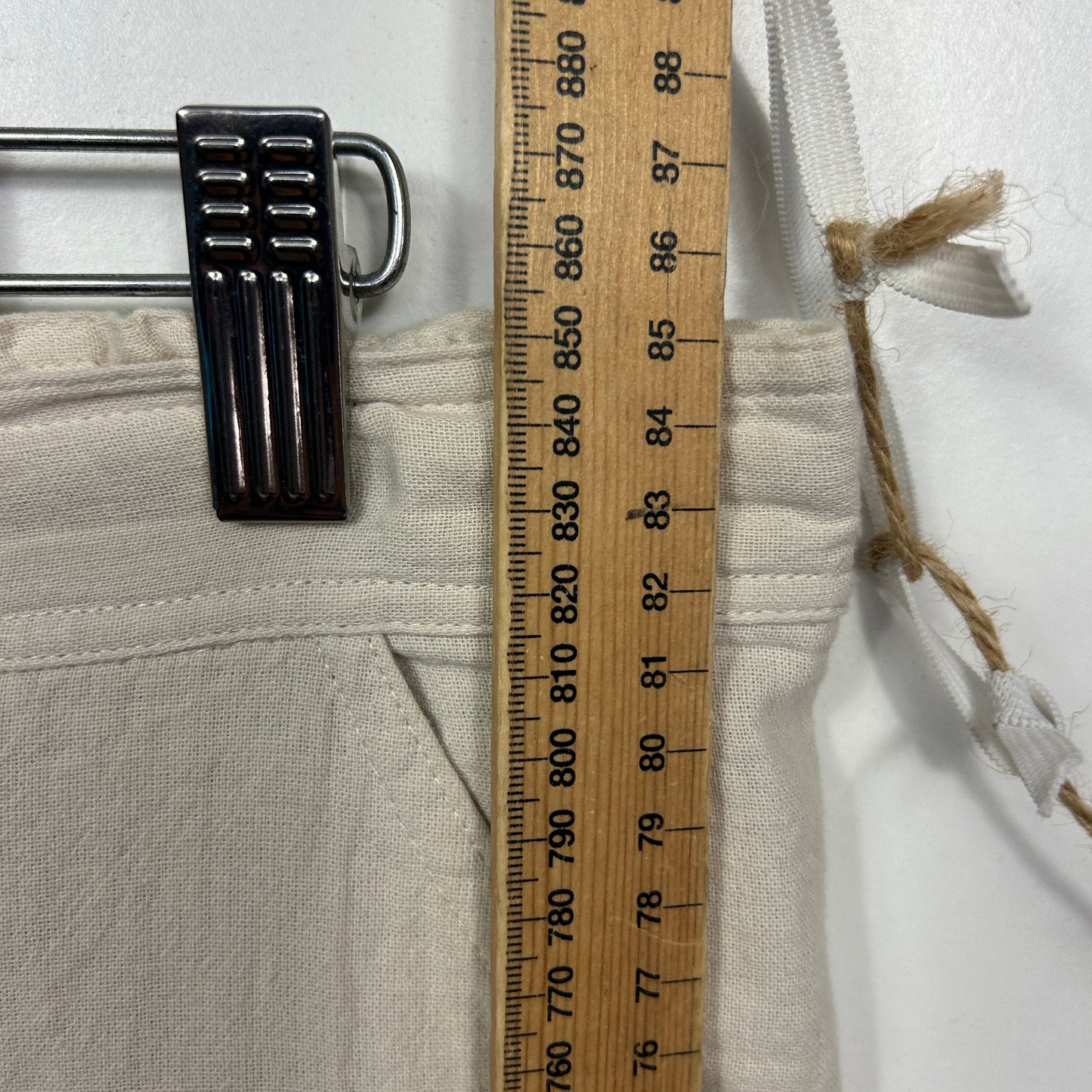 Cream garment with black buckle detail view