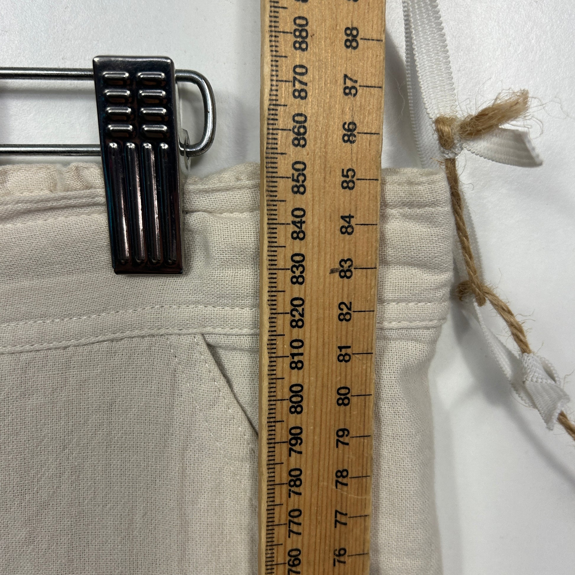 Cream garment with black buckle detail view
