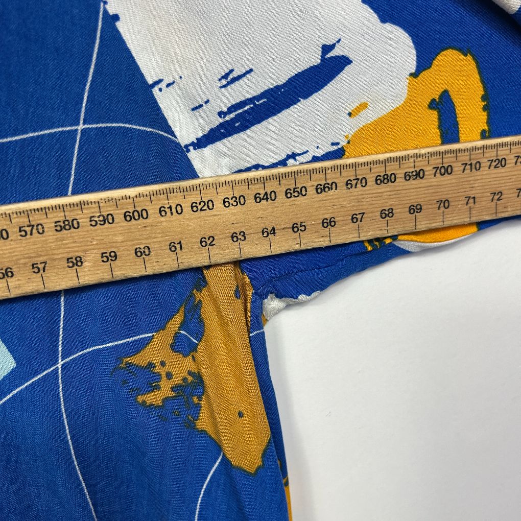 Blue fabric with map graphic and yellow measuring tape detail view